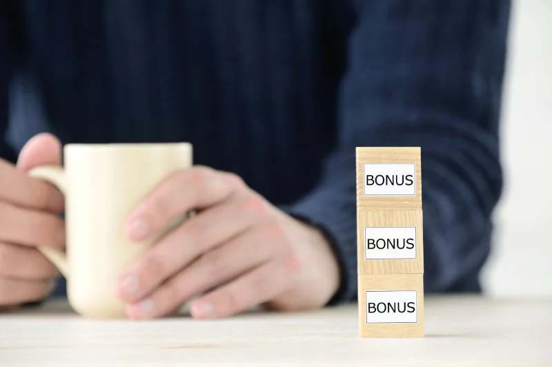 Cubes de bois marqués « bonus » à côté d’une tasse