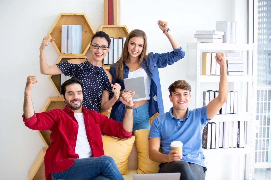 Groupe de jeunes souriants levant les bras