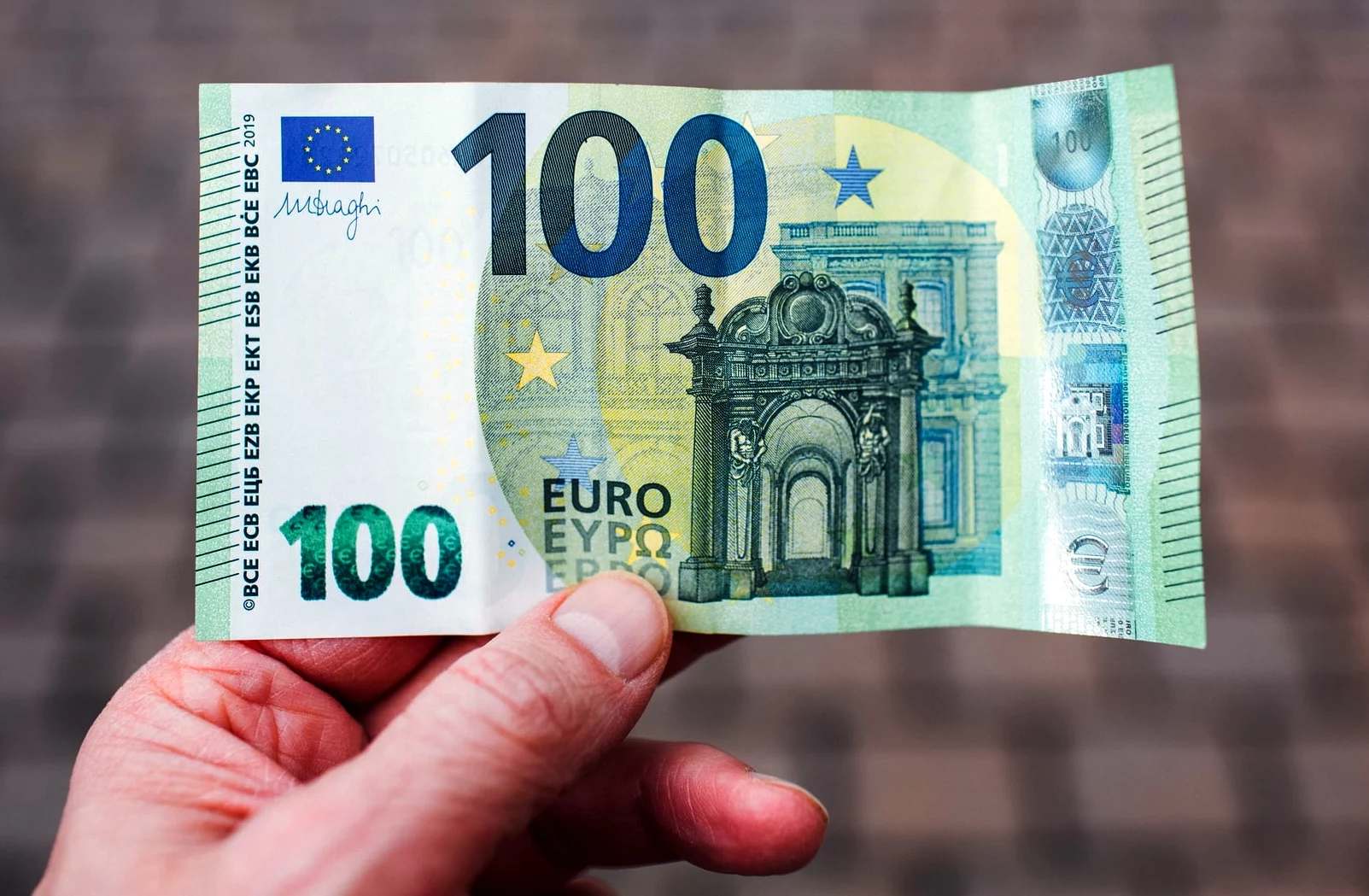 Main tenant un billet de 100 euros