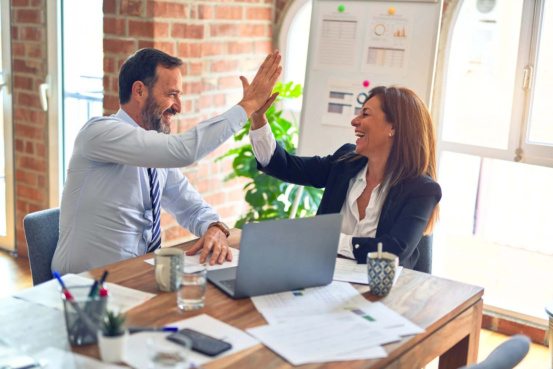 Collègues, un homme et une femme, se tapant dans la main au bureau