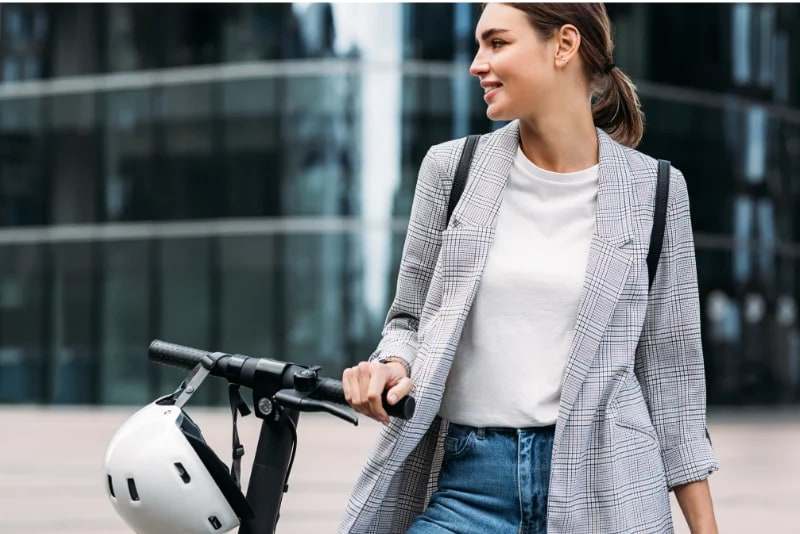 Femme se rendant au travail avec sa trottinette électrique